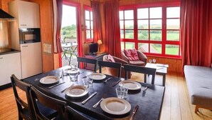 A cozy room with a dining table set for four, a sofa, and a bed.