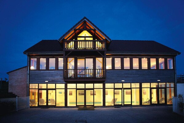 A two-story building with a balcony and large windows.