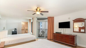 A hotel room with two beds, a ceiling fan, a television, a dresser, and a balcony with a view.