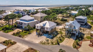 Un quartier résidentiel situé sur la côte, où les maisons sont dotées de vastes jardins, dont certaines ont des terrasses et quelques-unes présentent des meubles d’extérieur visibles.