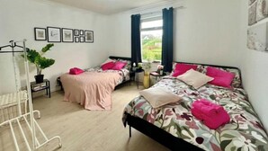 A bedroom with two beds, a wardrobe, a window with curtains, and a ceiling light. - Holly street house with Separate Entrance, on the Edge of Glasgow
 (Clydebank)