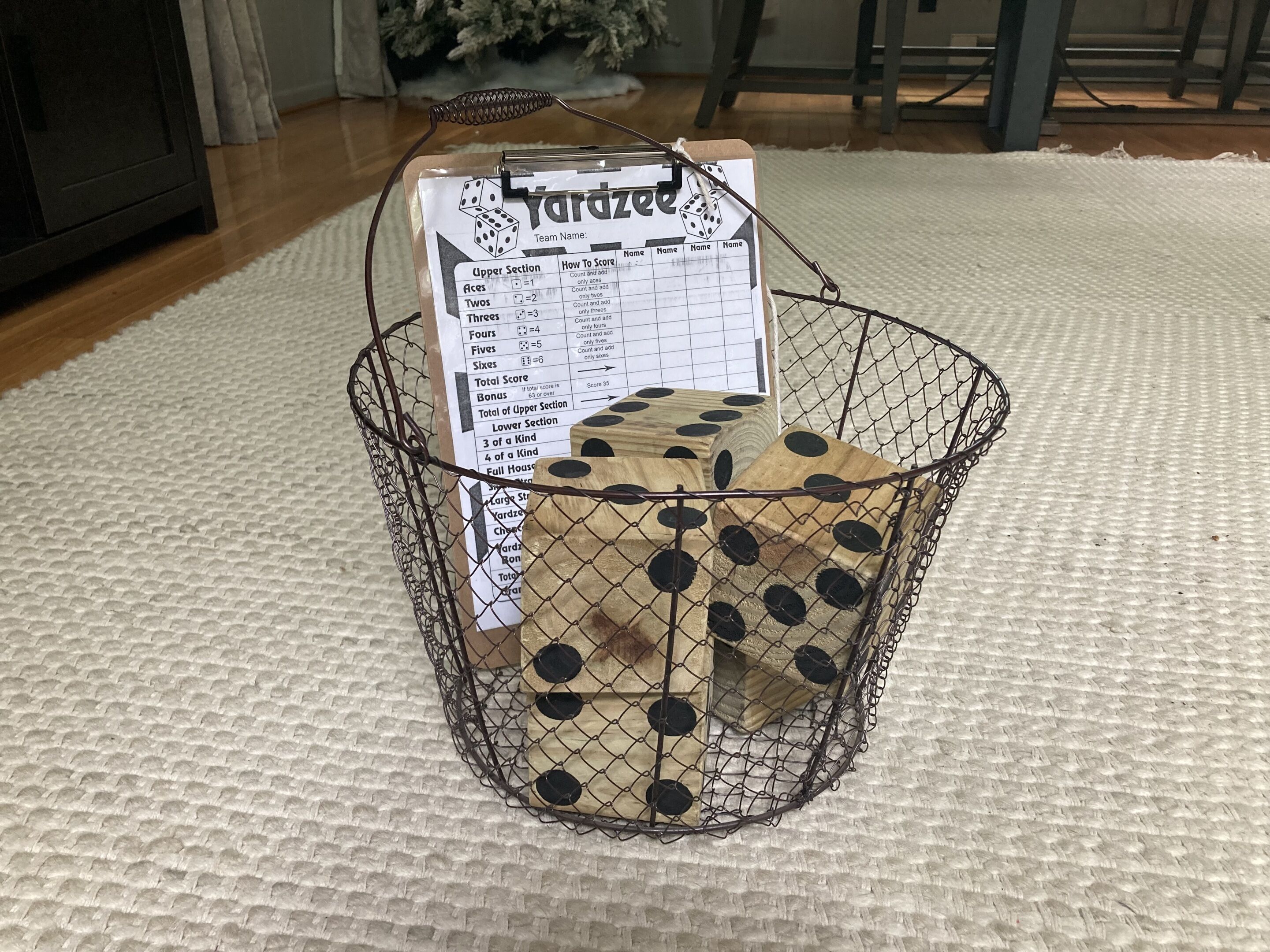 A dice in a wire basket with a yardzee scorecard attached.