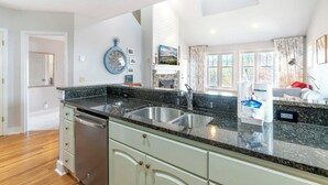 A kitchen with granite countertops, stainless steel appliances, and a clock on the wall. - Hawks Peak 406- Mtn Condo, Top Floor, Mtn View, Modern, Near Attractions (Seven Devils)