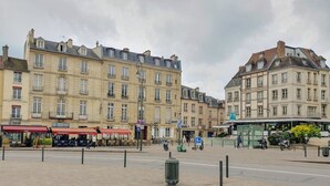 A paved square with buildings, a bus stop, and a café. - Large studio - city center - 300 m RER A (Saint-Germain-en-Laye)
