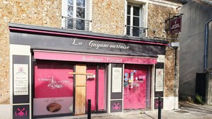 Ein Bäckereischaufenster mit der Aufschrift "La Guyancourtoise", einem rosafarbenen Vordach und einem Schild, das daraufhinweist, dass es Brot und Gebäck verkauft.