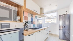 A modern kitchen with a microwave, oven, sink, and refrigerator. - Beautiful flat 2 rooms near Paris/La Défense (Suresnes)