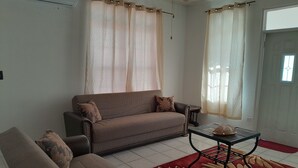 Un salon avec un canapé, un fauteuil et une table basse.
