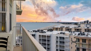 Un edificio de gran altura con varios balcones que dan a una playa y al océano.