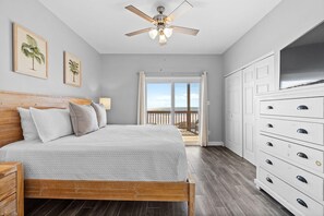 A bedroom with a bed, ceiling fan, and a view to a balcony. - Hypnautic East (Gulf Shores)