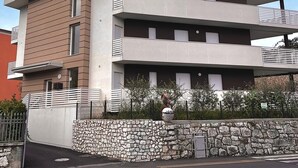 Un bâtiment moderne à deux étages, doté d’une façade en pierre et d’un toit plat.