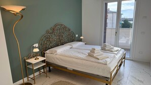 Une chambre à coucher avec un lit, une lampe sur pied, une table de chevet et une vue sur l’extérieur, accessible par une porte coulissante.