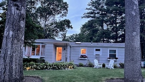 A single-story house with a front porch, a small deck, and a well-maintained lawn.