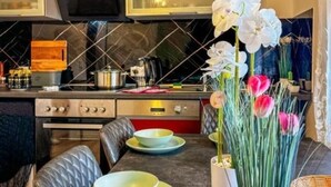 Una cocina moderna con una isla central, horno empotrado y microondas. Hay tulipanes blancos y rosados en la isla.