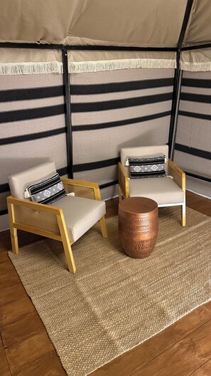 Relax in a serene, intimate space with a striped fabric wall and plush seating for two.