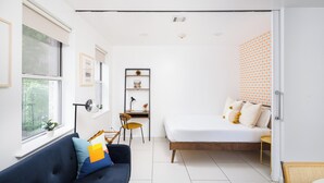 A modern bedroom with a bed, a desk, and a sofa. - Beautiful 2 beds Apt in Midtown NYC #301 (New York)