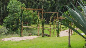 En træstruktur i en frodig grøn park med træer og en belagt sti.