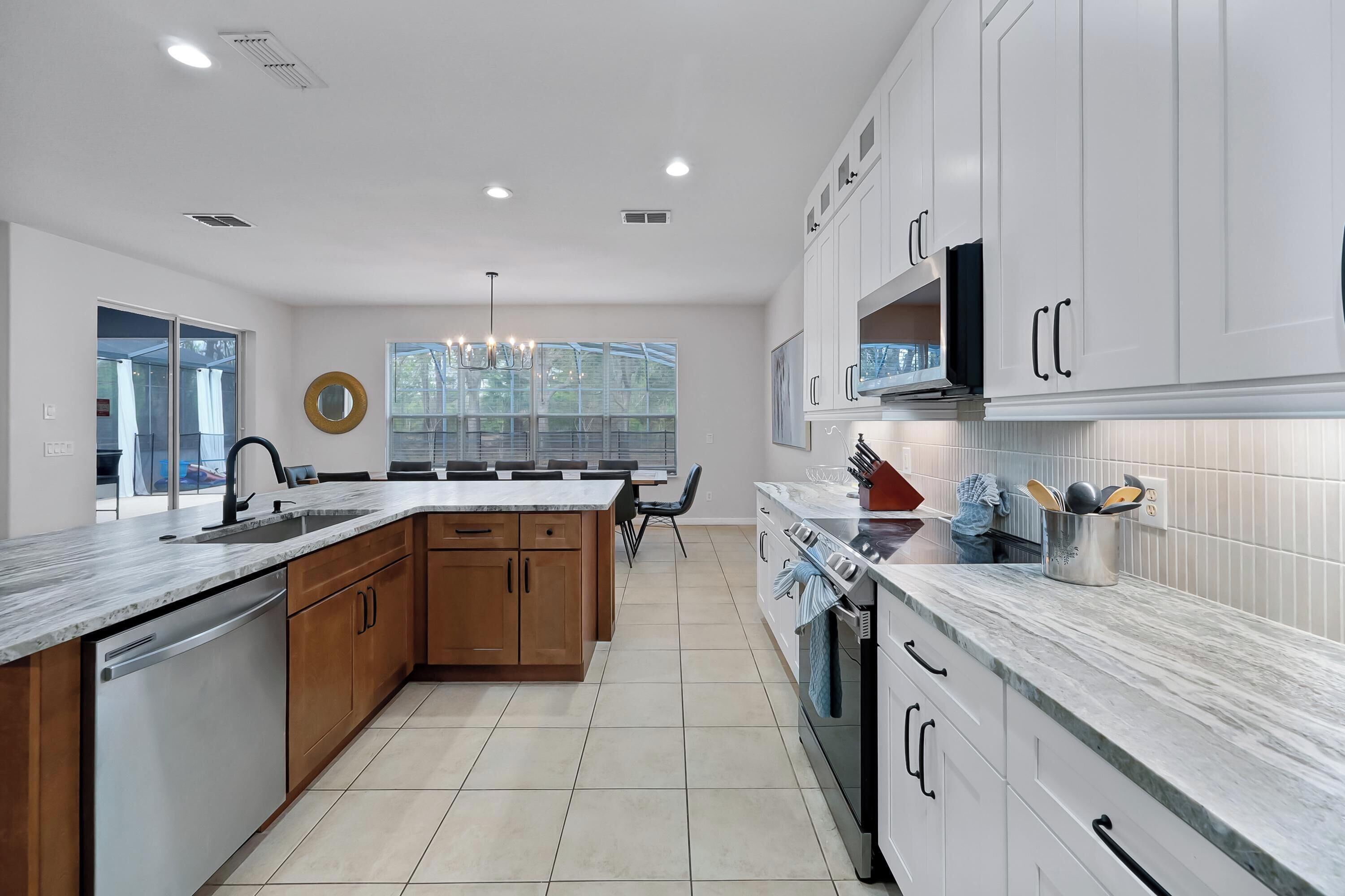 A modern kitchen with white cabinets, a granite countertop, and a central island.