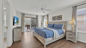 A bedroom with a bed, nightstands, a ceiling fan, and a view to a balcony. - Cozy Retreat 4BR-walk to Resort's Lazy River,pools-12 miles to Walt Disney World (Davenport)