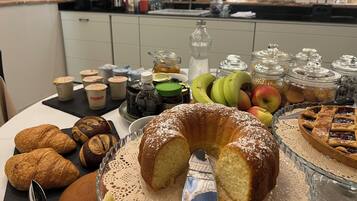 A breakfast buffet with pastries, fruits, and condiments.
