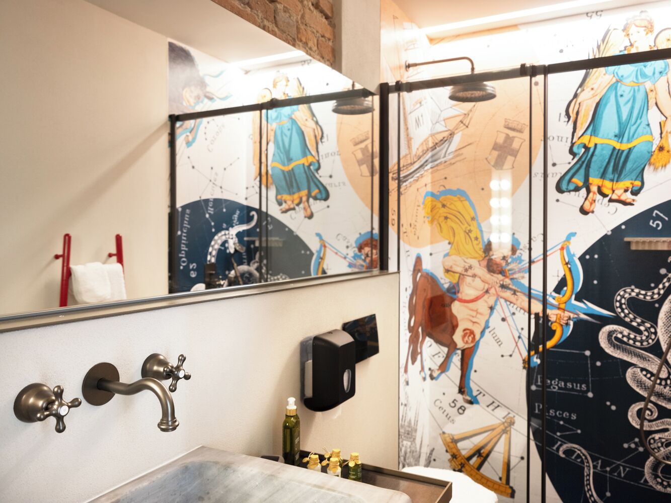 A bathroom with a sink, a mirror, a towel rack, and a shower area with a glass door.