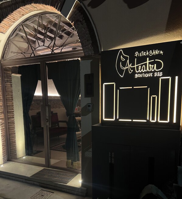 An entrance to a boutique hotel with a glass door, a curtain, and a sign reading "Pietrasanta Teatro Boutique B&B". - Pietrasanta Ai Teatri (Pietrasanta)