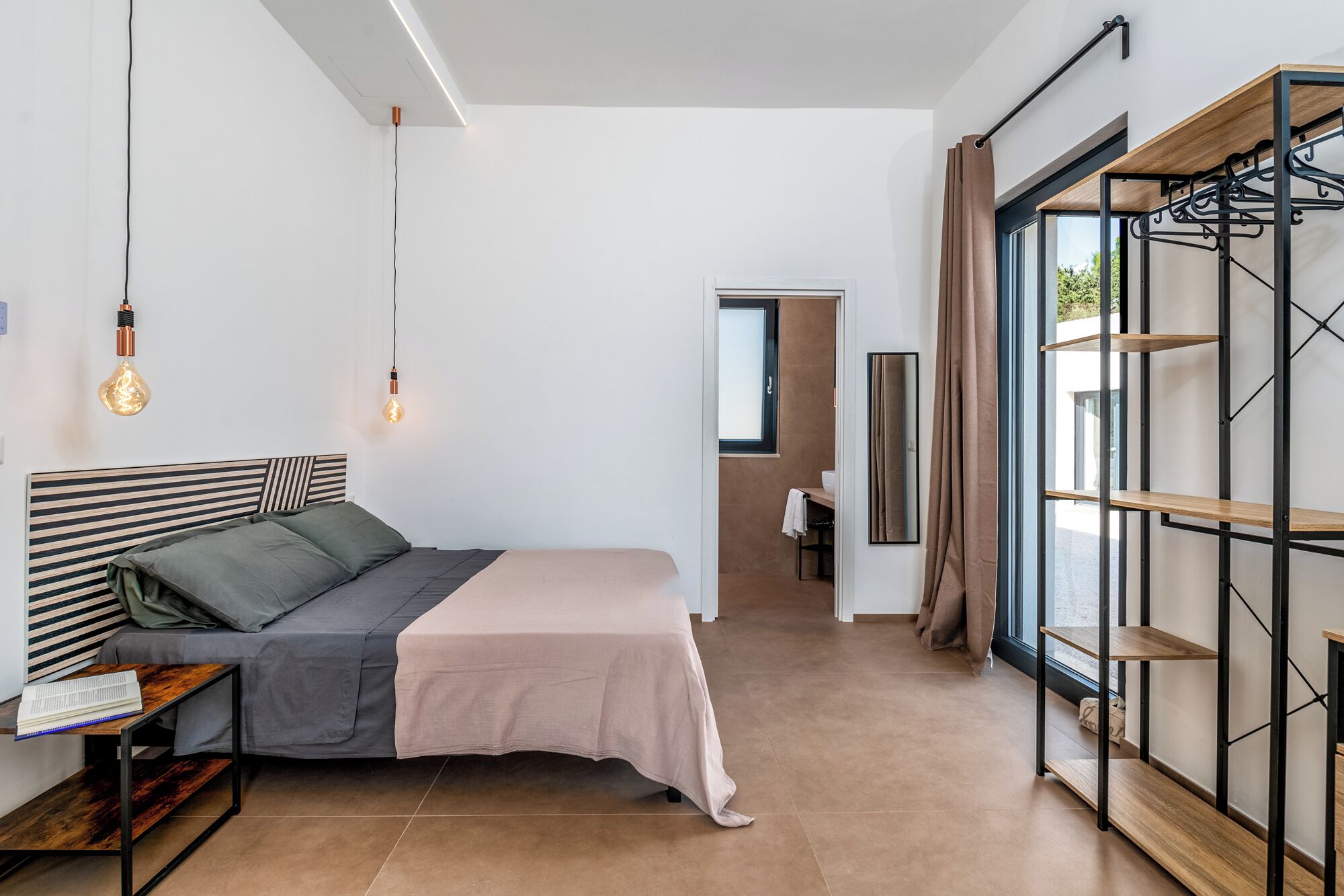 Ein modernes Schlafzimmer mit einem Bett, einem Nachttisch und einem Kleiderschrank mit Regalen.