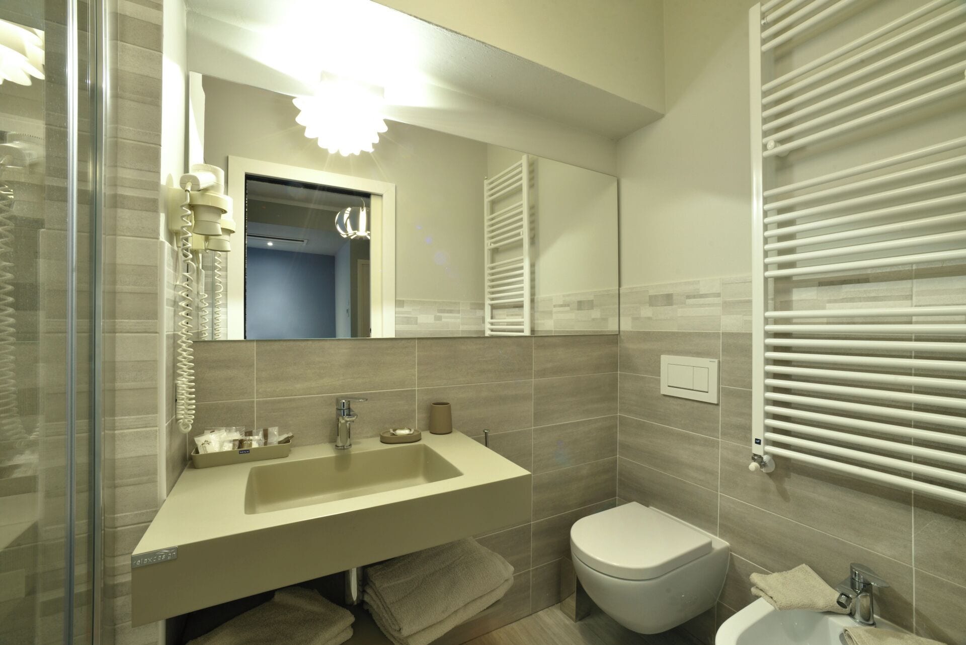 Un baño moderno con un lavamanos grande, un inodoro y un bidé.