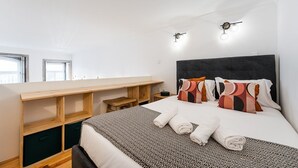 Ein modernes Hotelzimmer mit einem großen Bett, einem Holztisch und einem kleinen Tisch.