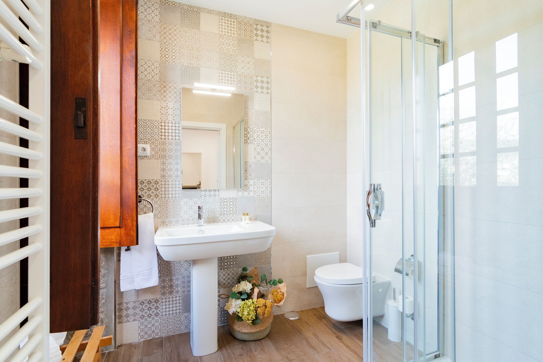 Ein modernes Badezimmer mit Waschbecken, Toilette und Duschkabine aus Glas.