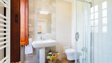 Ein modernes Badezimmer mit Waschbecken, Toilette und Duschkabine aus Glas.