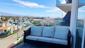 Ein Balkon mit einer Couch und Blick auf eine Stadtlandschaft.