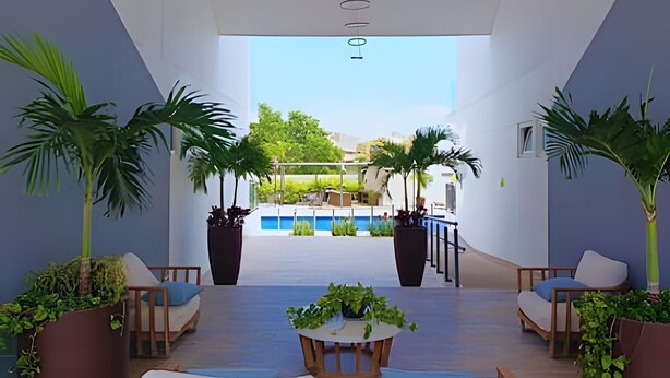 Ein moderner Lounge-Bereich mit Blick auf den Pool, ausgestattet mit Sitzgelegenheiten und Topfpflanzen.