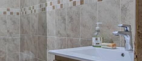 Une salle de bain moderne équipée de toilettes, d’un lavabo et d’une zone douche.