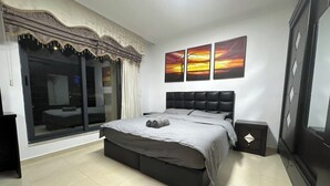 Ein Schlafzimmer mit einem großen Bett, einer Schiebetür und Blick ins Freie.