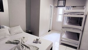A hotel room with a bed, a bunk bed, a bedside table, a nightstand, a window, and a ceiling light. - Solar Centro (Rio de Janeiro)
