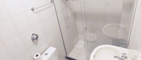 A modern bathroom with a glass-enclosed shower, a toilet, and a sink.