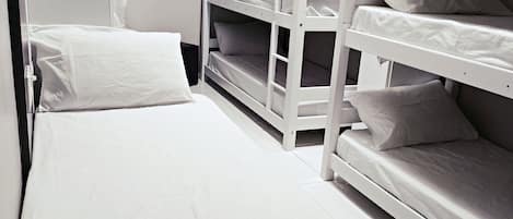 A bunk bed room with a single bed and a built-in heater.