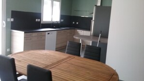 A compact kitchen with a dining area. - Charming new house with terrace and garden (Muron)
