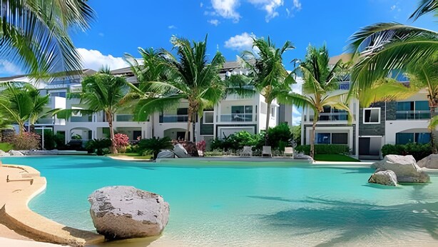 A resort with a large pool, palm trees, and modern buildings.
