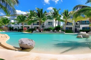 Een resort met een groot zwembad, palmbomen en moderne gebouwen.