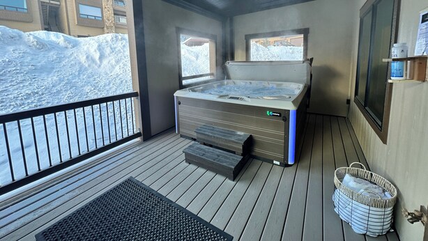 Un cuarto de spa con hidromasaje, una ventana y vistas a un paisaje nevado.