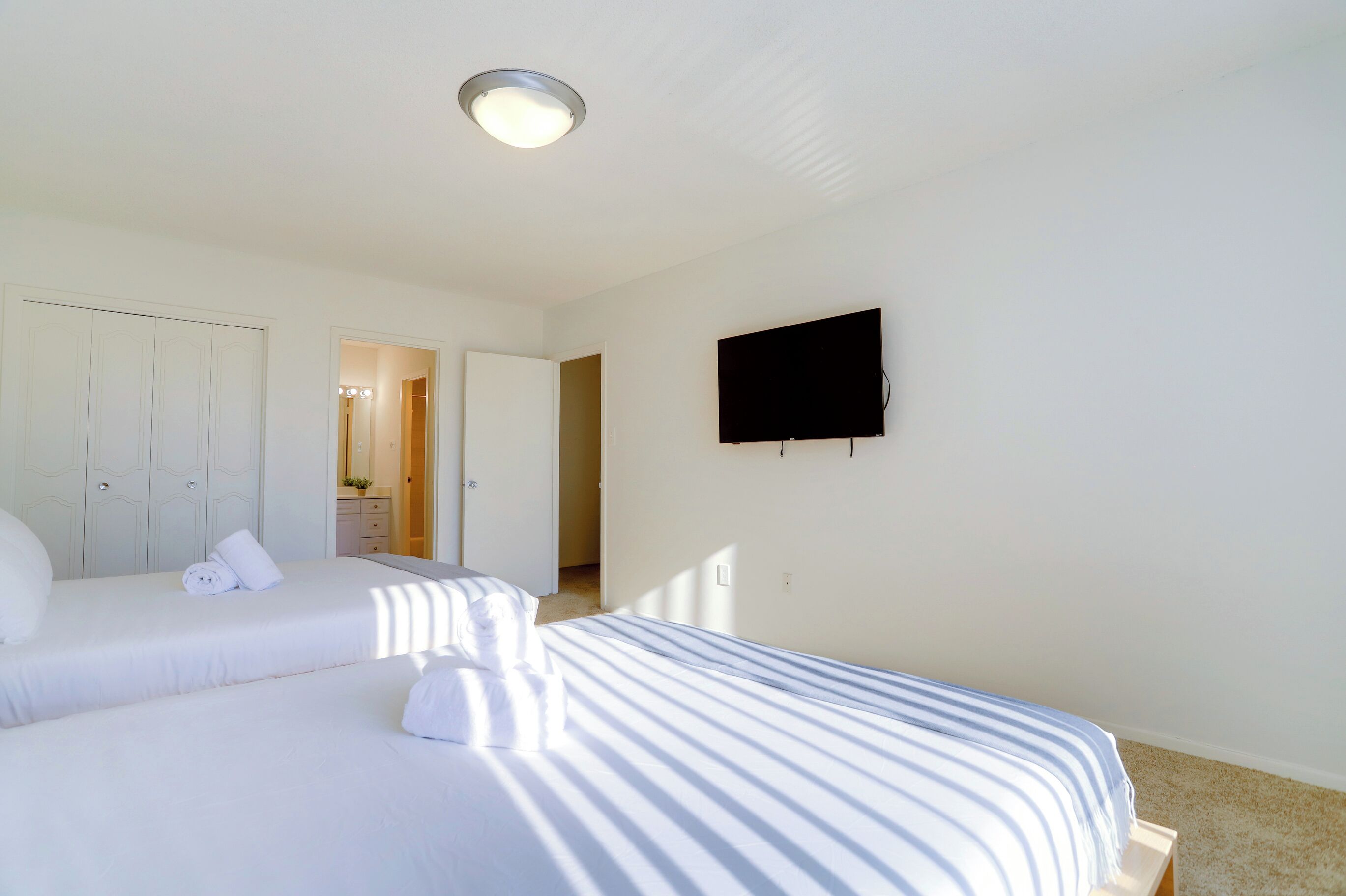 Un dormitorio con dos camas, un televisor y un armario.