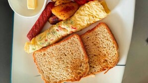 A breakfast plate with toast, eggs, potatoes, sausage, and a tomato. - Joy Beach Lodge (Sekondi-Takoradi)