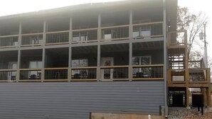 Un immeuble à plusieurs étages, doté d’un toit plat et d’un balcon au dernier étage.