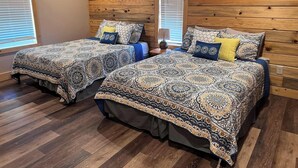 Une chambre avec deux lits, des têtes de lit en bois et une fenêtre avec des stores.