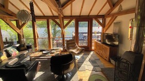 A cozy cabin with a wooden interior, a fireplace, and a view of a lake.