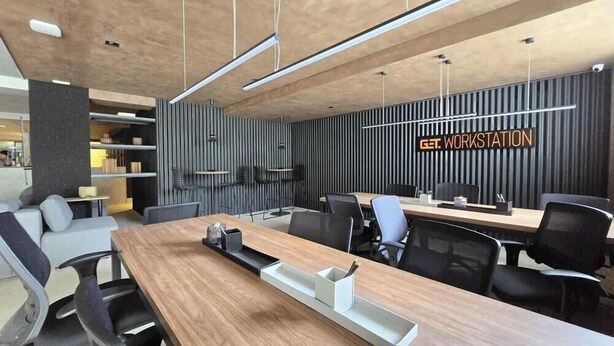 A modern conference room with a long table, chairs, and a 'GET WORKSTATION' sign on the wall. - Get By Side (João Pessoa)