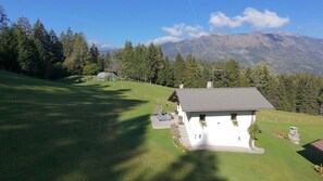 A white building with a grey roof, surrounded by a well-maintained lawn and a row of trees. - Baita Mountain View Pale San Martino (Fiera Di Primiero)