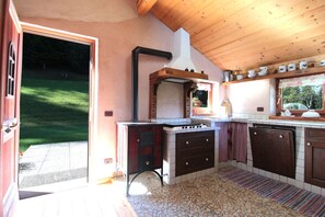 A kitchen with a stove, sink, and wooden cabinets. - Baita Mountain View Pale San Martino (Fiera Di Primiero)
