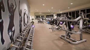 A gym with exercise equipment, a mirrored wall, and a carpeted floor. - Icon 2B|2B Fully Remodeled Frontline Bay and Pool (Miami)